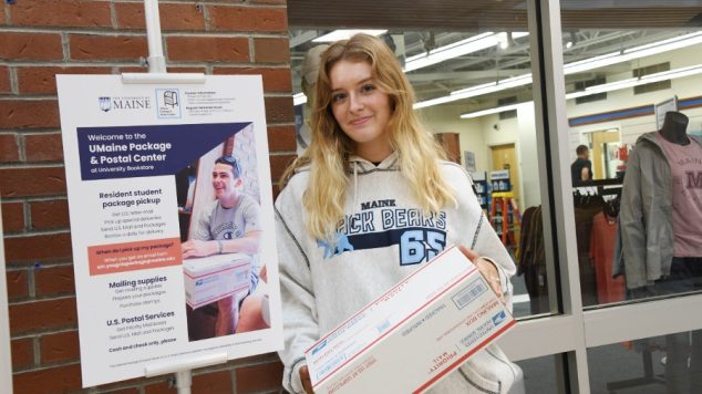 Student posing with package
