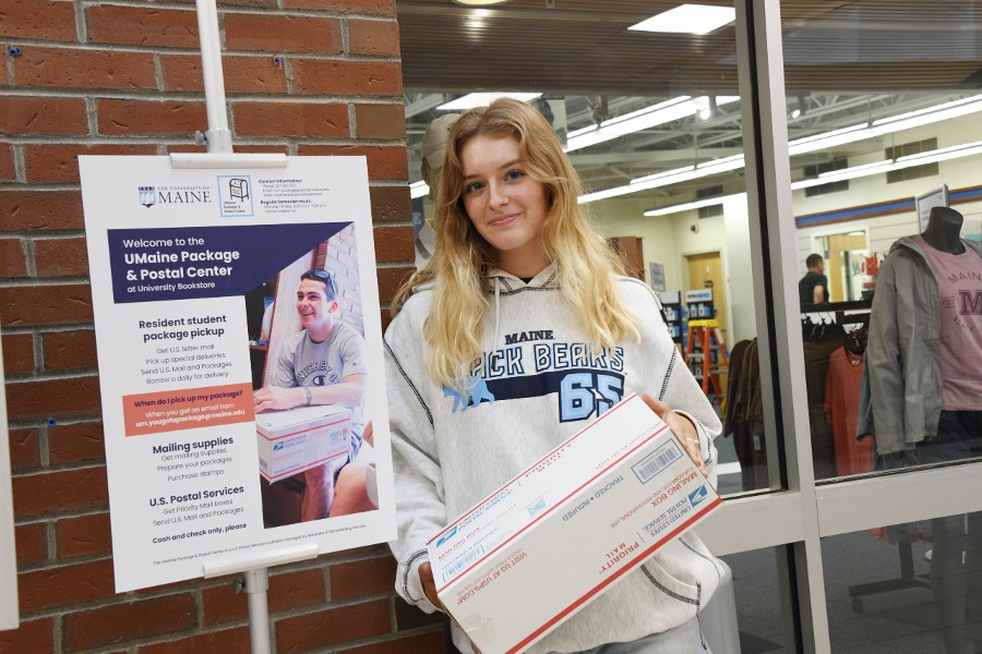 Student posing with package