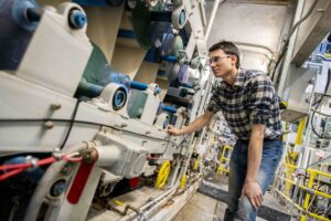 A Process Development Center employee examining a papermaking machine