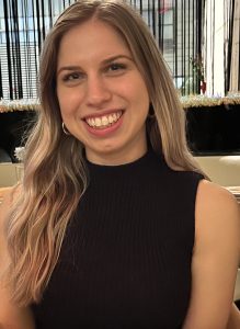 Portrait of Graduate student Daniella Gelman smiling into camera. Wearing black top