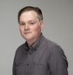 A young adult man (Robby Finley) with a vignette around a grey background.