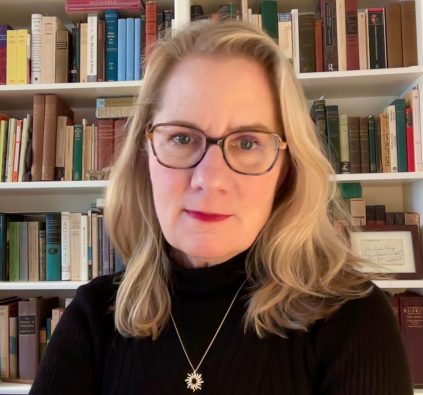 Headshot of Professor Moxley in front of a bookshelf