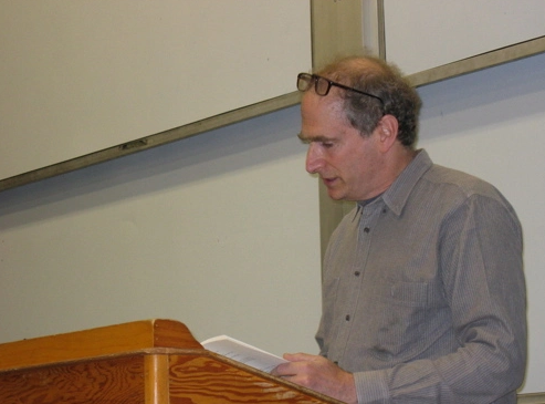 Bob Perelman reading out of book behind podium