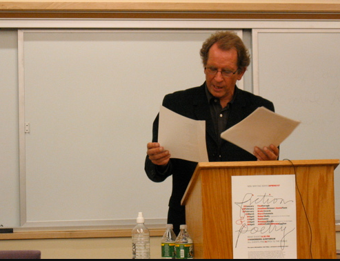 Michael Davidson reading aloud off a manuscript behind a podium