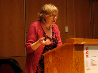 Geraldine Monk reading behind a podium