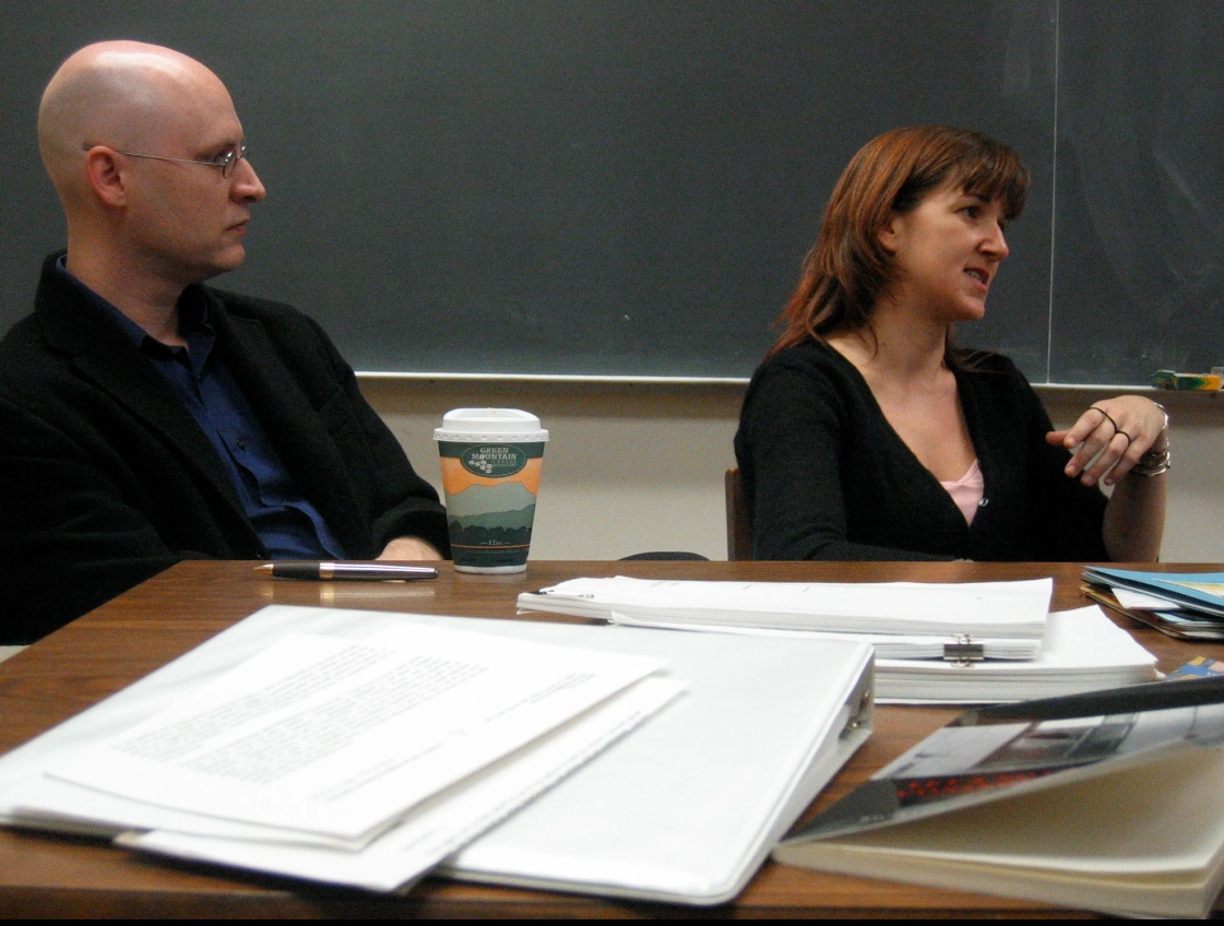 Richard Deming and Nancy Kuhl siting behind a table speaking to other(s) out of frame