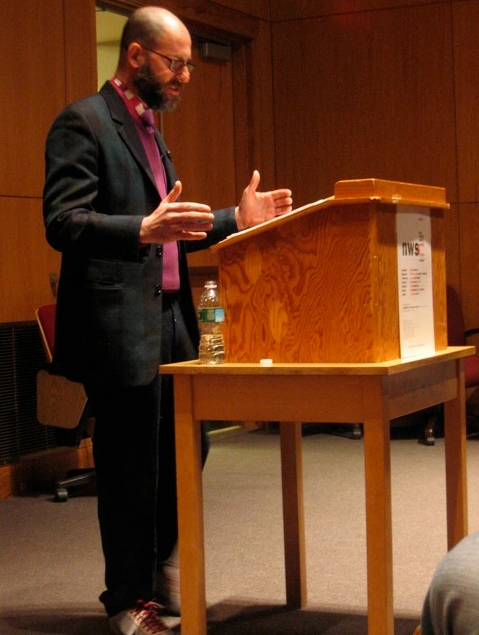 Kenneth Goldsmith reading behind a podium
