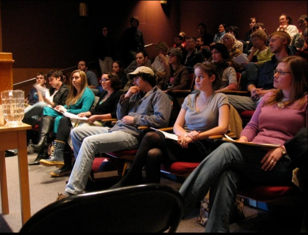 Audience of students and faculty looking at a stage