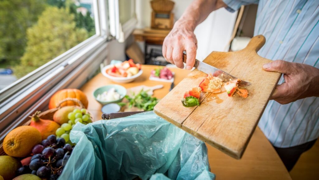 image of person putting food waste in garbage