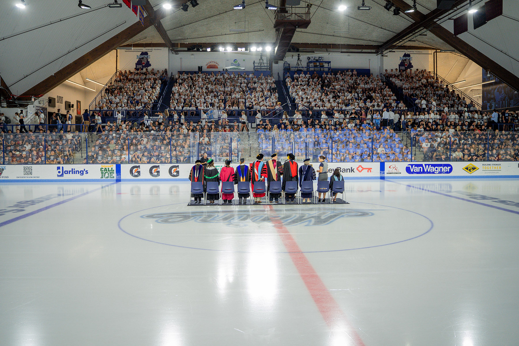 A group photo of the students assembled for Fall 2026 Convocation, students are seated in Alfond Arena with faculty leadership standing on the hockey arena's ice rink in the foreground.