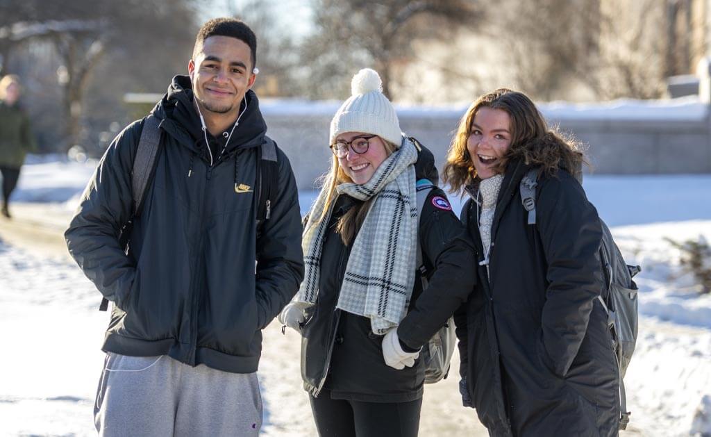 A photo of three people on UMaine's campus in winter