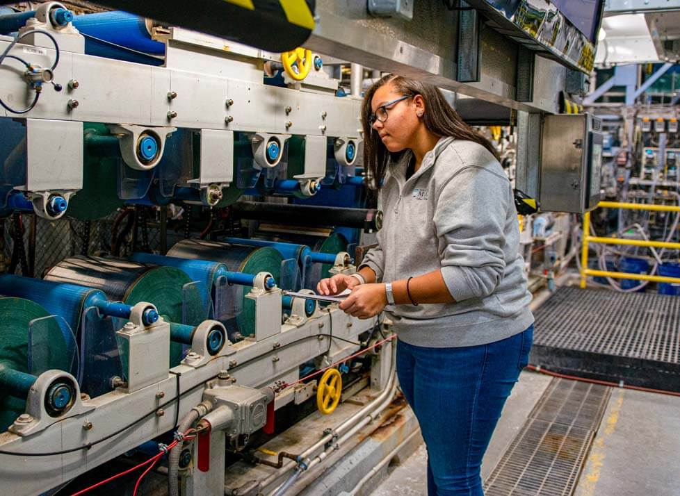 A photo of a woman standing in front of a large machine