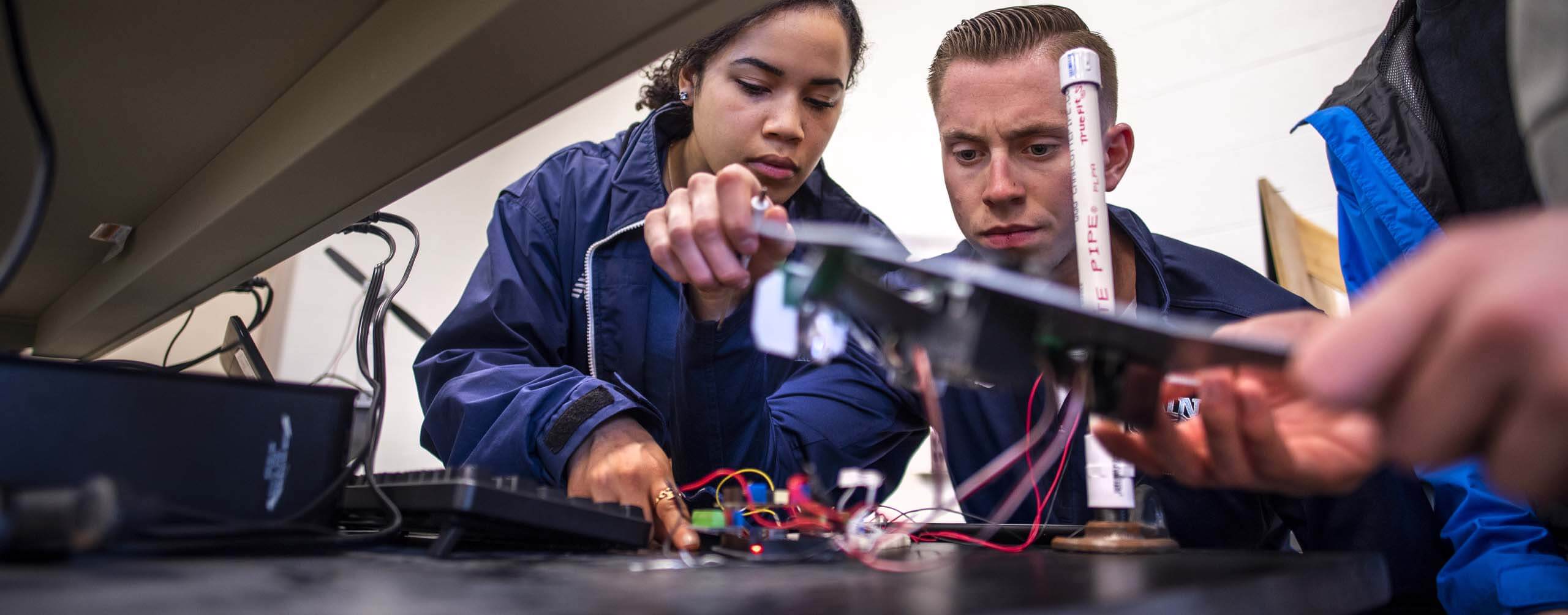 A photo of three people in an engineering lab