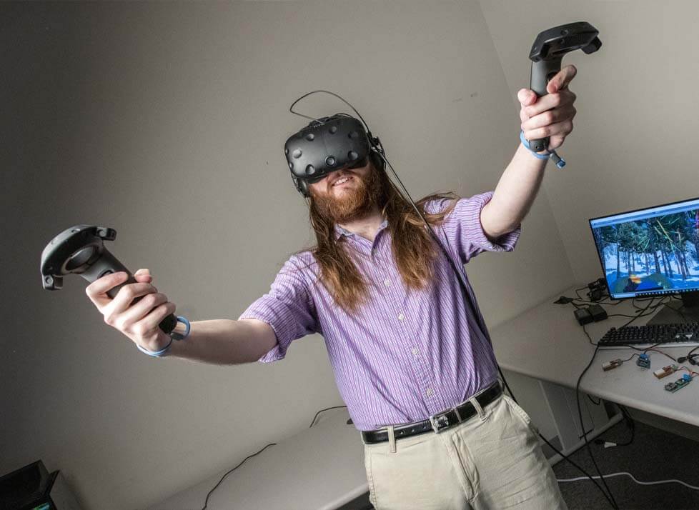A photo of a person wearing a VR headset and holding controllers
