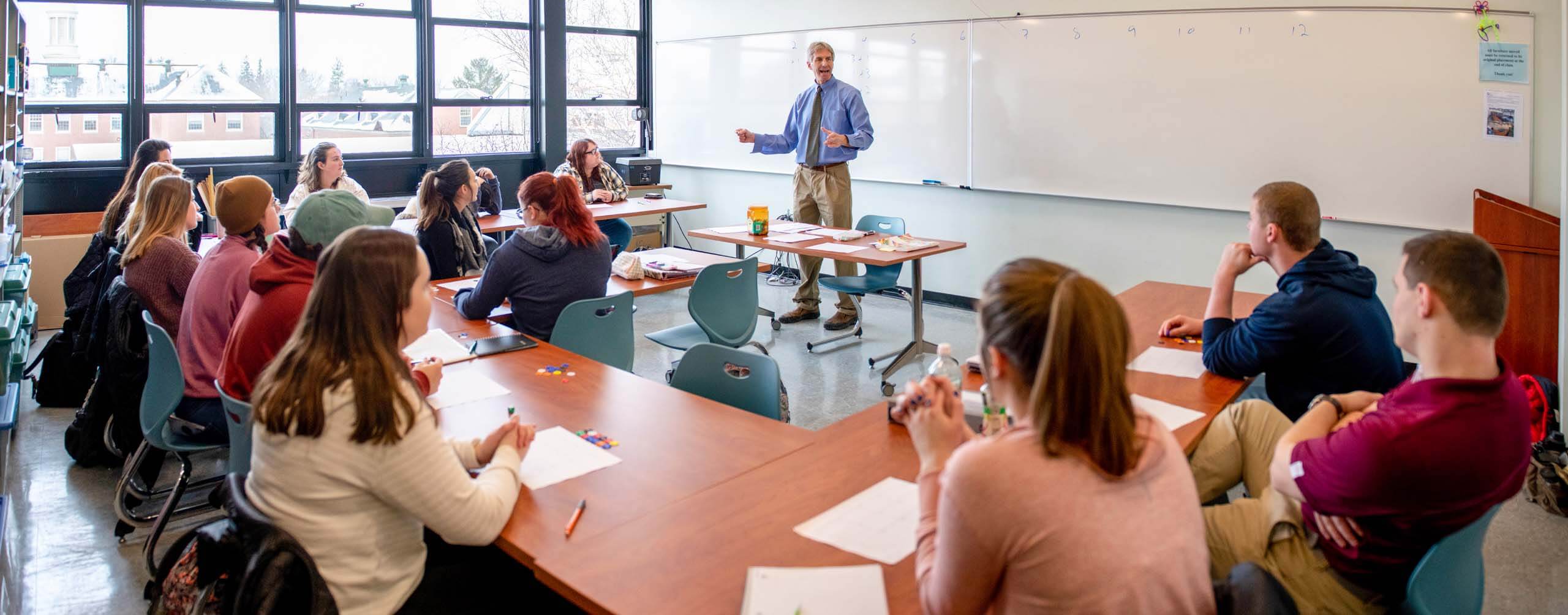 A photo of a classroom of students listening to a teacher
