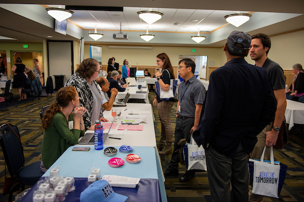 New faculty members mingle with table representatives at 2018 new faculty orientation.