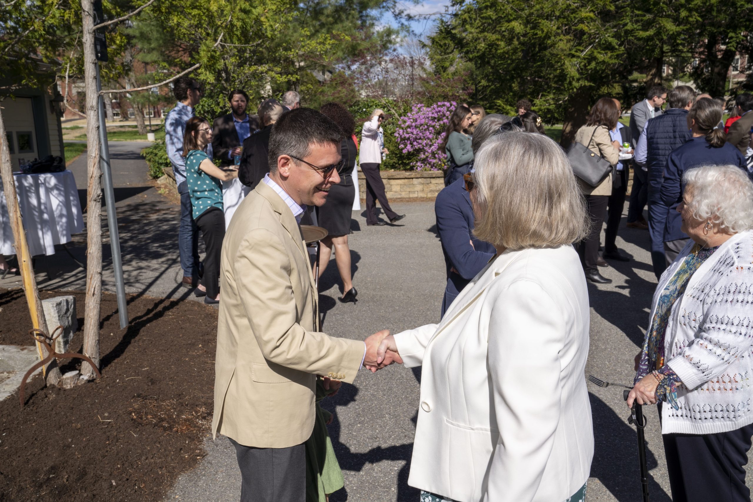 President Ferrini-Mundy shaking a faculty member's hand at a Promotion and Tenure reception event at the President's house.