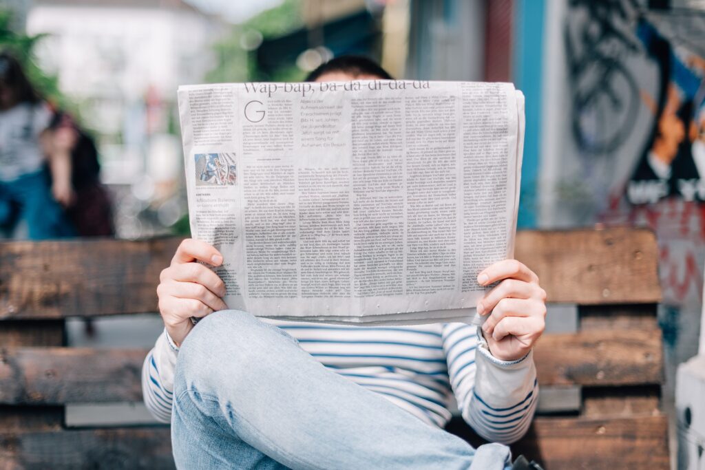 A person reading a newspaper.