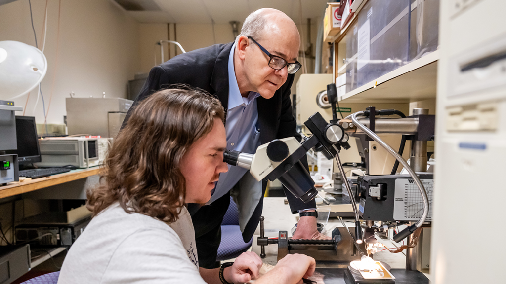 A professor and student work in a lab