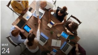 7 people collaborating around a table with laptops