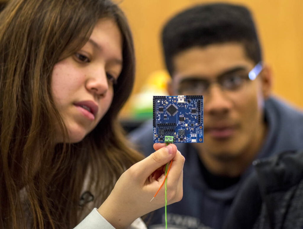 Two students look at a circuit