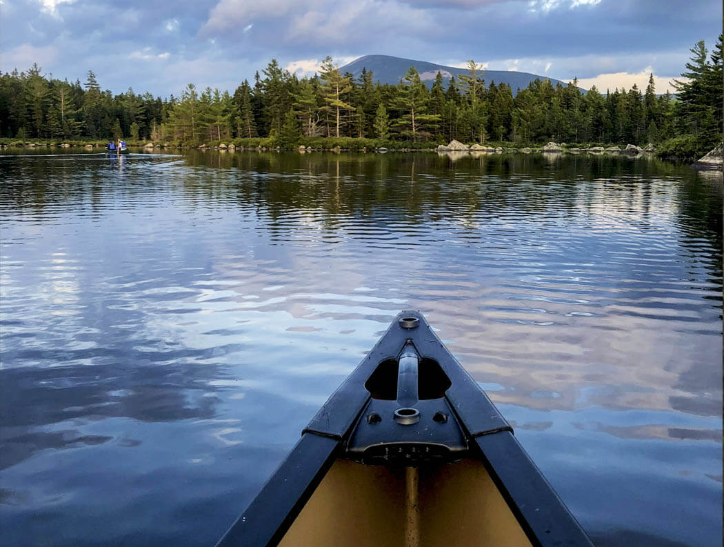 A canoe on a lake with mountains in the distance