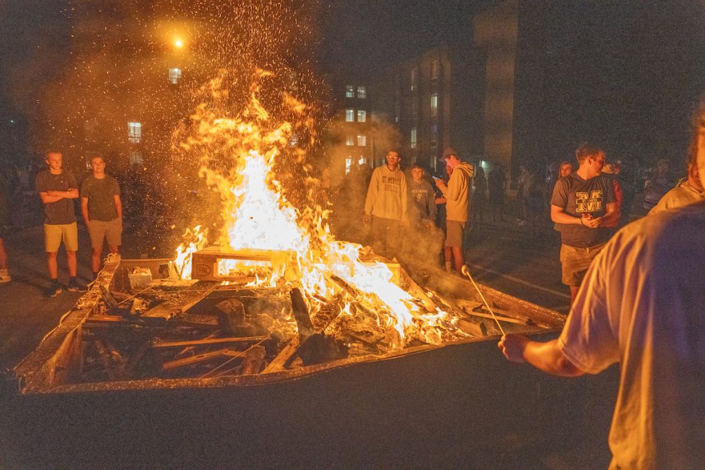 A photo of students sitting around a bonfire