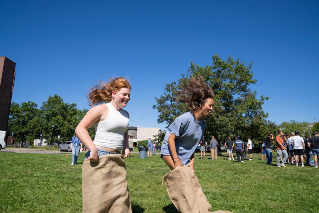 A photo of two students in a potato sack race