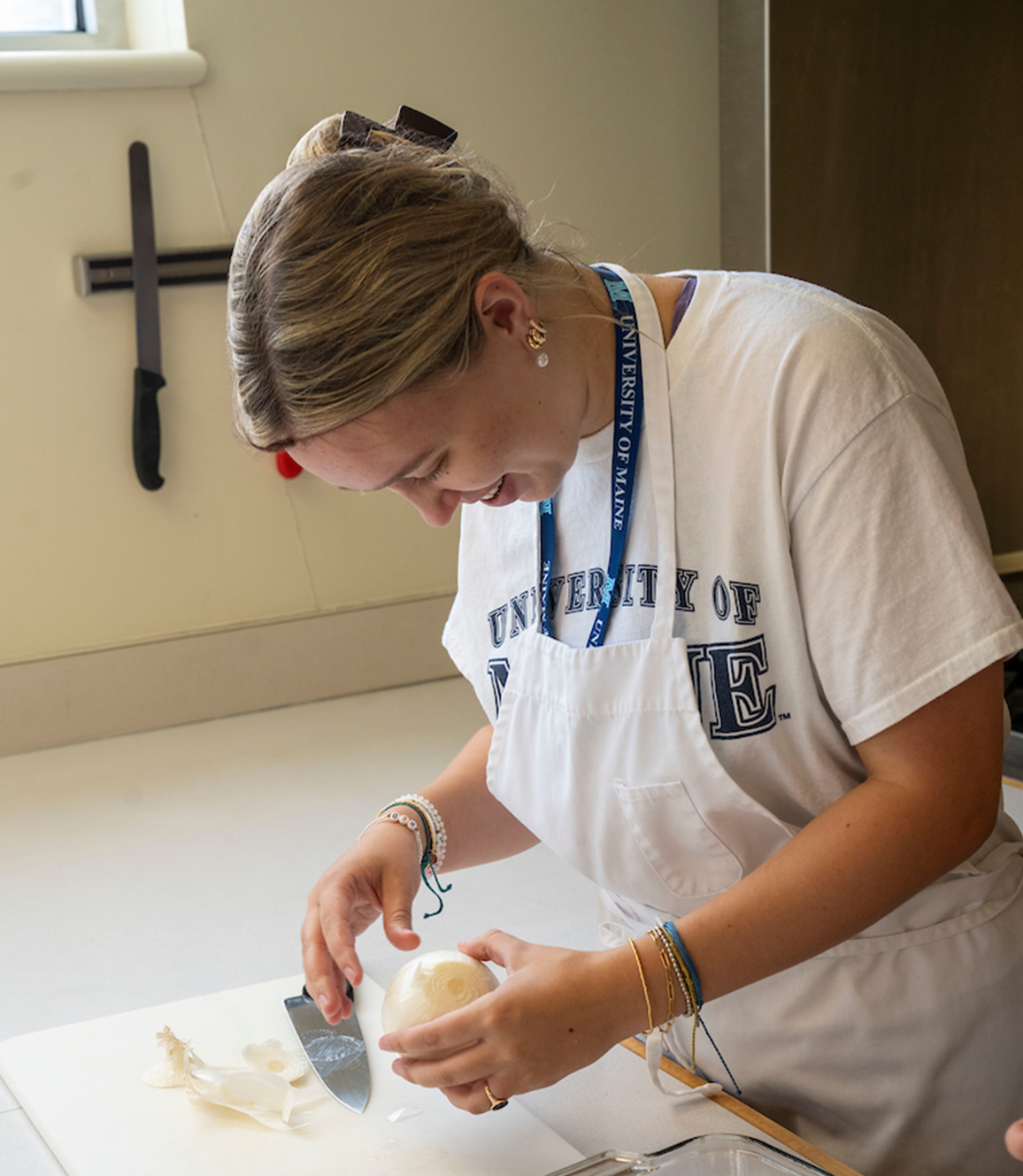 A photo of a student cutting an onion