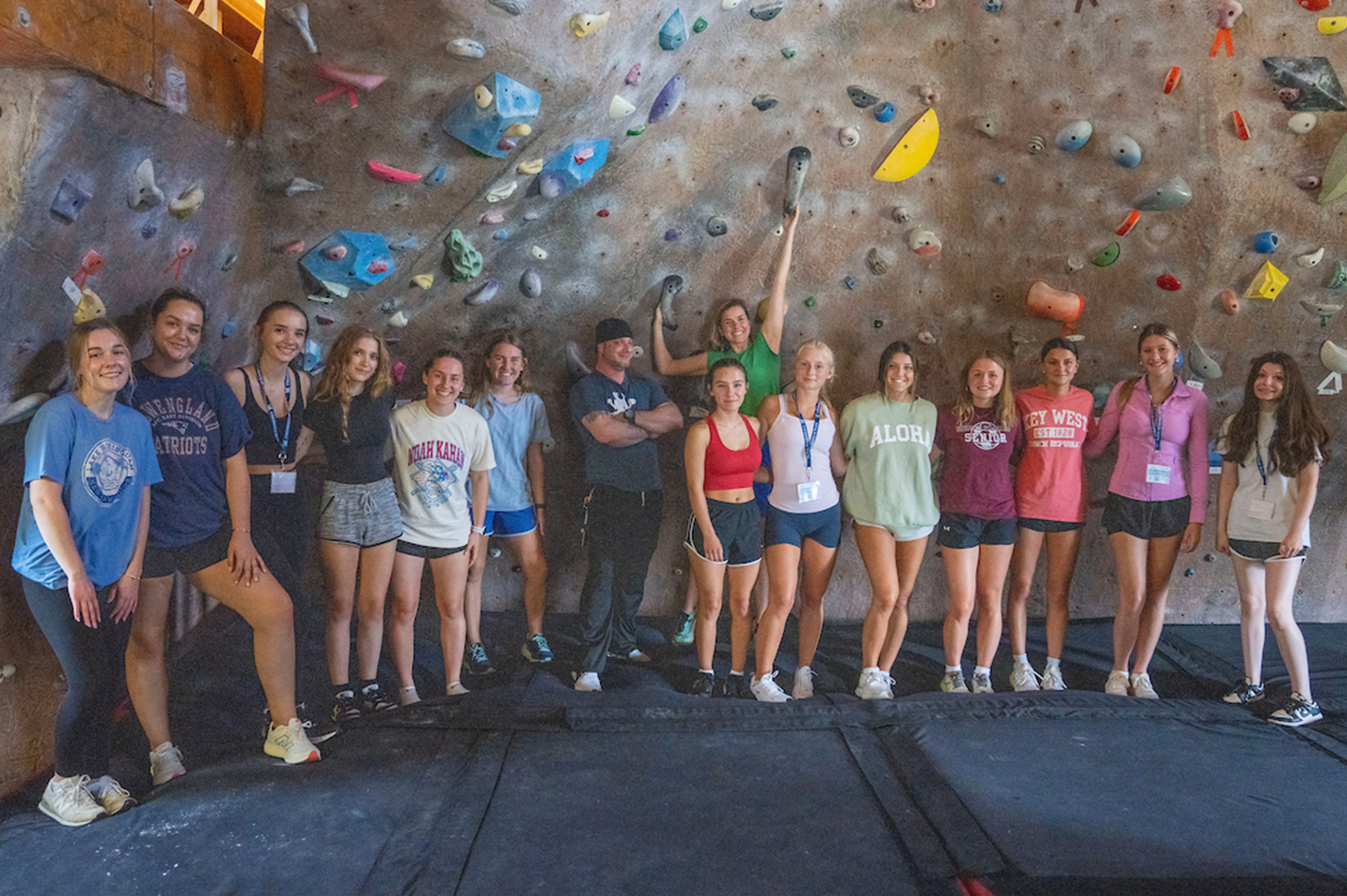 A photo of students next to a rock climbing wall