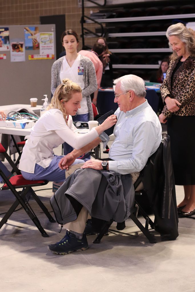 Image of student checking blood pressure of attendee