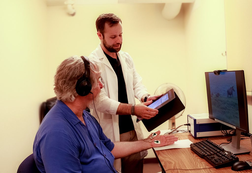 Colin Bosma performs a mood induction on Michael Robbins, Chair, Department of Psychology