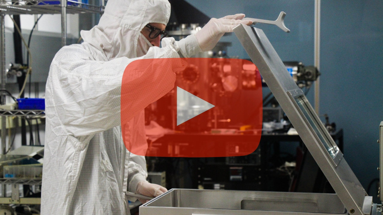 Play button over researcher in cleanroom