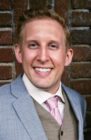 A photo of Drew Hooke in a suit