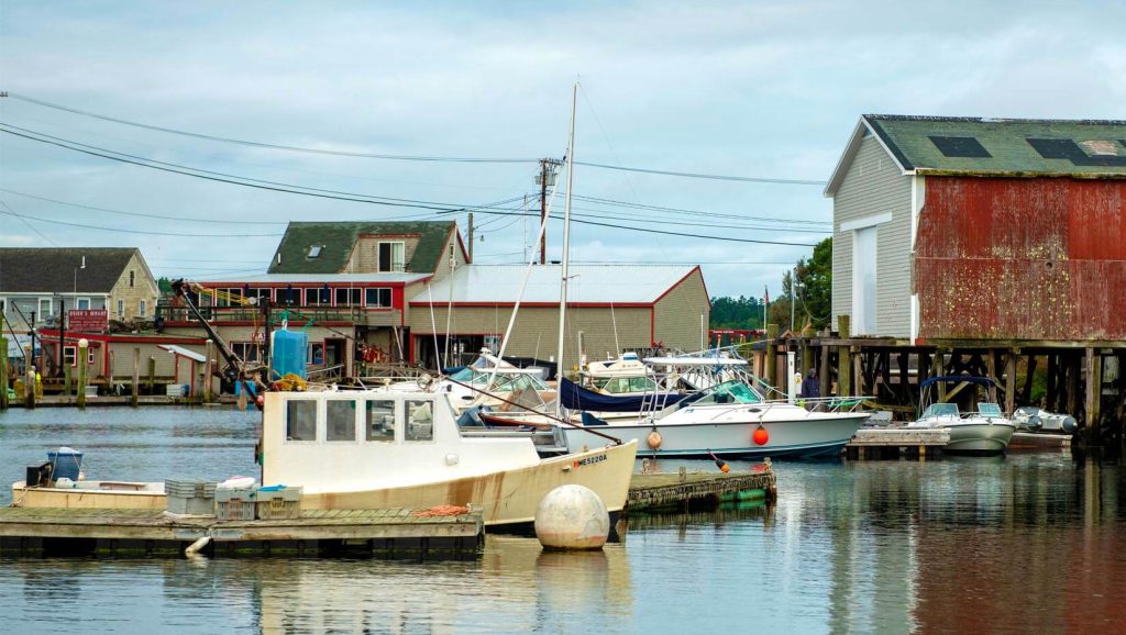 White boat in front of small Maine town's waterfront 