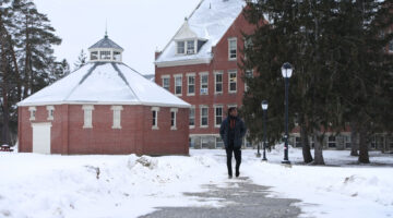 A student walks a path on campus in this UMaine winter scene