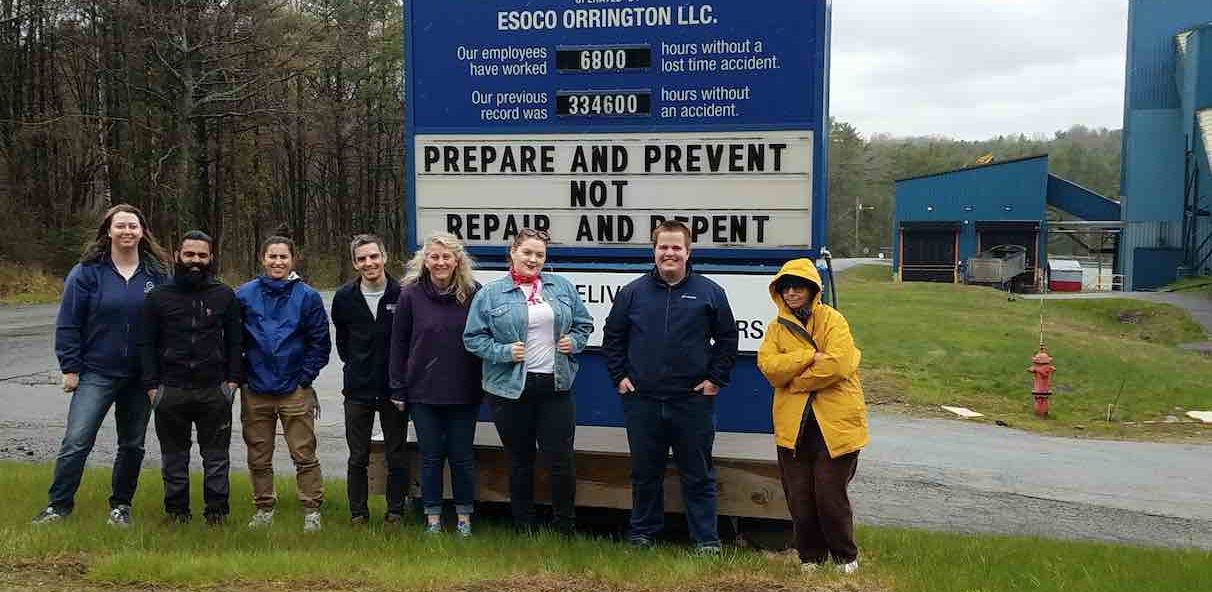 group photo of students in front of a sign