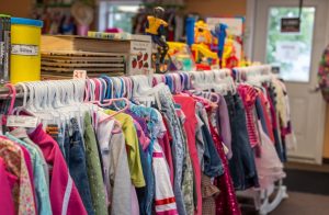 row of colorful used kid's clothes at consignment shop