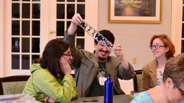 Group of teachers collaborating on a DNA model