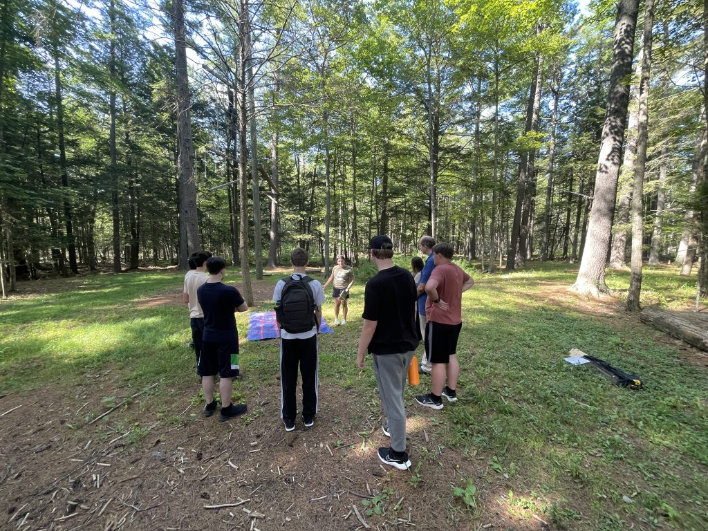CCG - Getting ready to solve a maze while standing in UMaine's beautiful wooden challenge area.