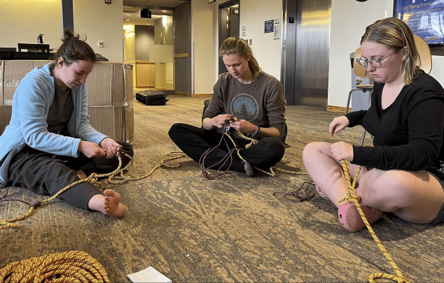 Three students practicing rope tying.