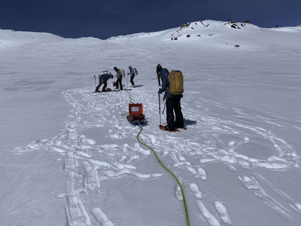 Students taking research gear across the Lemon Creek Glacier snowfield.