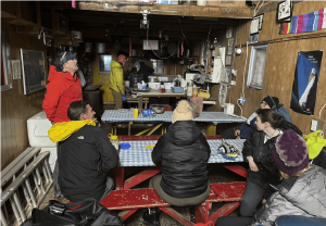 Research team sitting around tables in the JIRP Camp 17 cook shack.