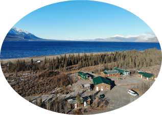 Aerial view of the Kluane Lake Research Station, including several lakefront buildings.
