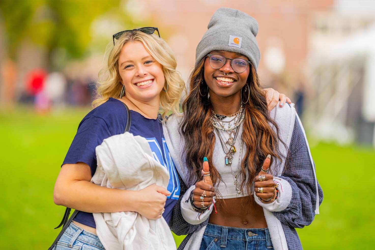 A photo of two people posing for a photo of UMaine's Mall