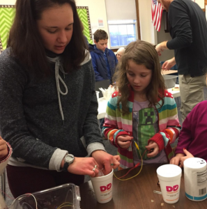 SMART Intern Annalyse works with a student in the STEM club to build a circuit