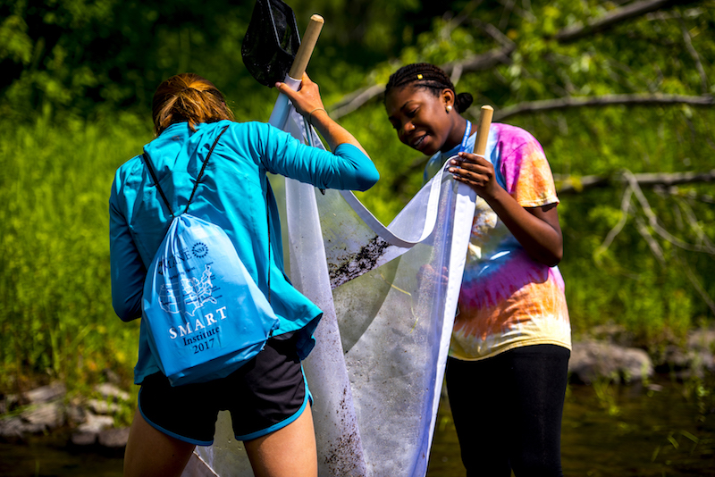 SMART students use a kick net to catch macroinvertebrates