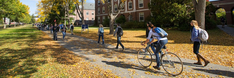 Students riding bikes and walking through the university mall in the fall