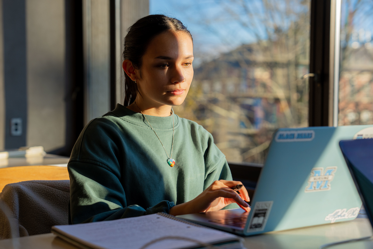 A photo of a student on a laptop