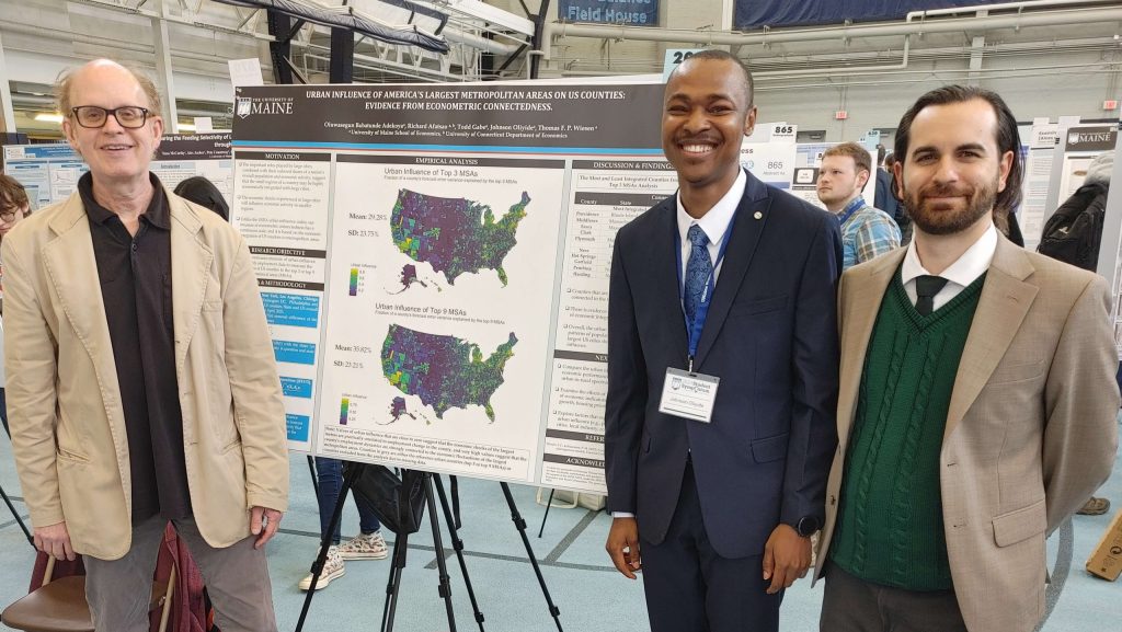 A photo of students and faculty with a poster board